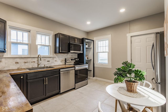 kitchen with stainless steel appliances, a healthy amount of sunlight, tasteful backsplash, and sink