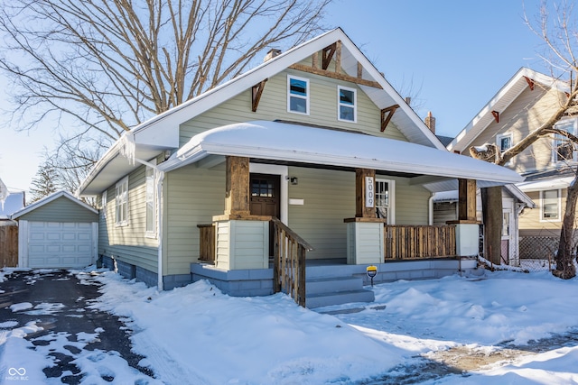 bungalow-style home featuring a garage, an outdoor structure, and a porch