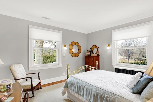 bedroom featuring light hardwood / wood-style flooring and multiple windows