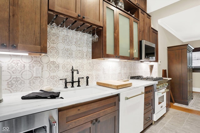 kitchen with sink, white appliances, backsplash, and beverage cooler