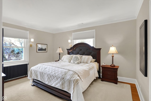 bedroom featuring hardwood / wood-style floors, radiator, and ornamental molding