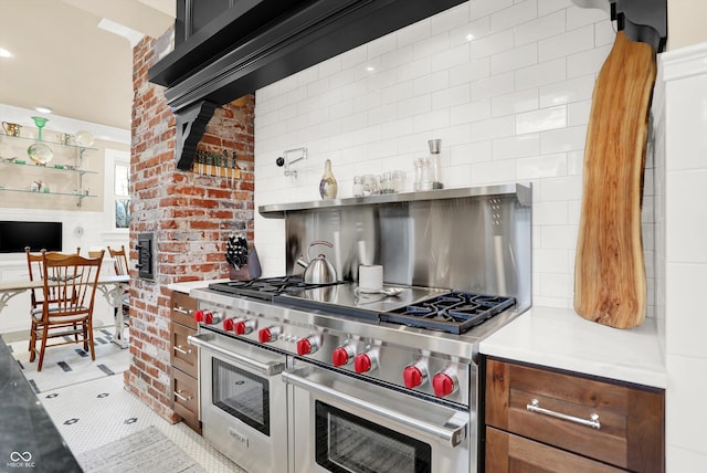 kitchen featuring tasteful backsplash, light tile patterned floors, and range with two ovens