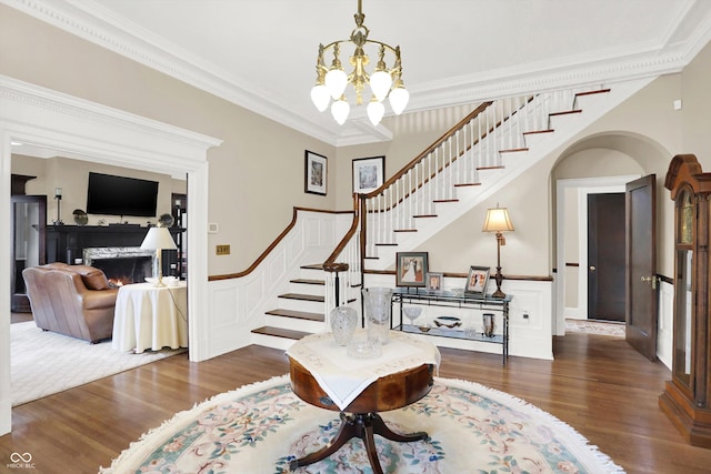 entryway featuring ornamental molding, dark wood-type flooring, and an inviting chandelier