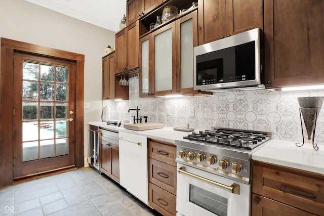 kitchen with decorative backsplash, appliances with stainless steel finishes, crown molding, and sink