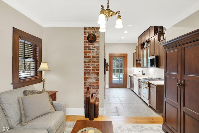 kitchen featuring decorative backsplash, stainless steel appliances, an inviting chandelier, and ornamental molding