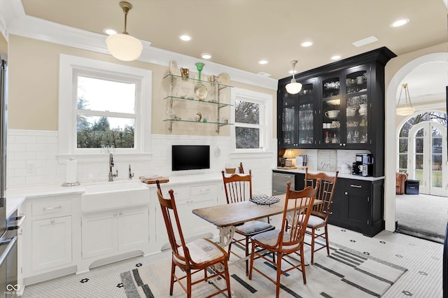 interior space featuring pendant lighting, crown molding, sink, and a wealth of natural light