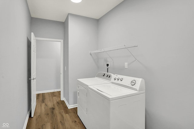 laundry area with hardwood / wood-style flooring and washing machine and clothes dryer