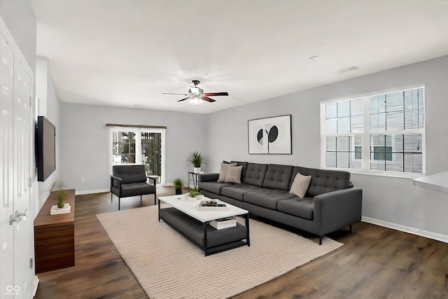 living room with ceiling fan and dark wood-type flooring