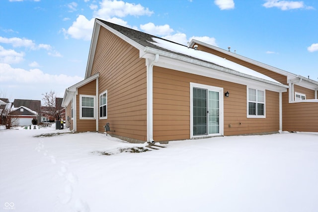 view of snow covered back of property