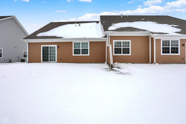 snow covered back of property with central air condition unit