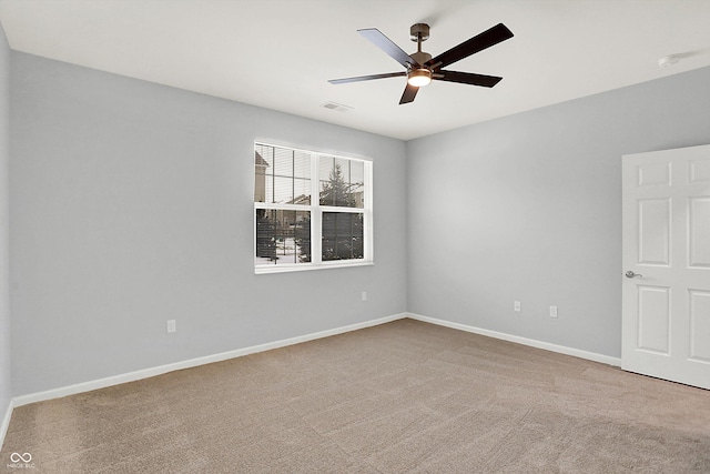 spare room with ceiling fan and light carpet