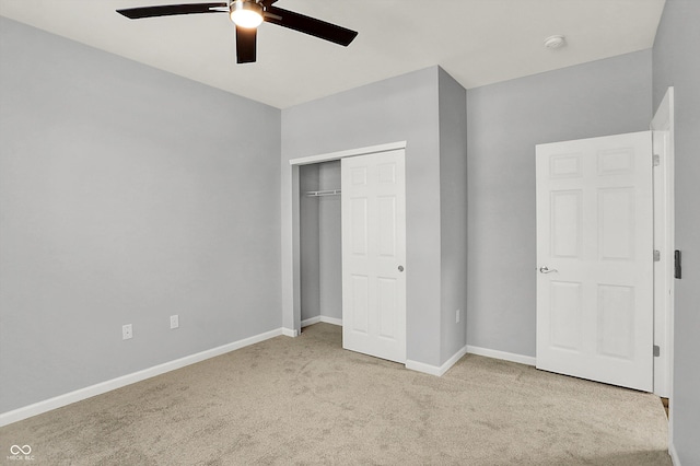 unfurnished bedroom featuring ceiling fan, light carpet, and a closet