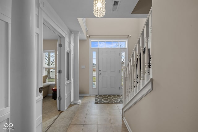 foyer entrance featuring light tile patterned floors, plenty of natural light, and a notable chandelier