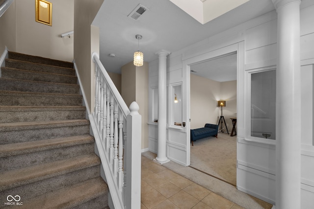 staircase with carpet flooring and decorative columns