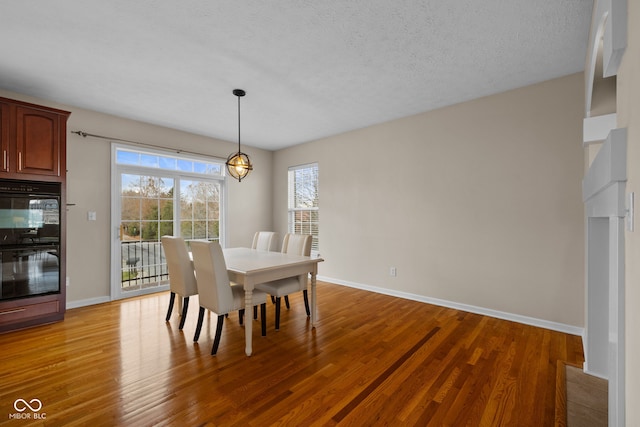 dining room featuring a textured ceiling and light hardwood / wood-style floors