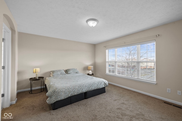 bedroom with carpet floors and a textured ceiling