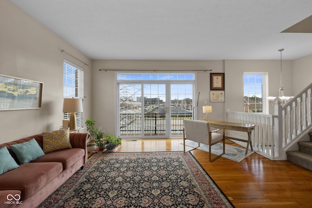 living room featuring hardwood / wood-style flooring, an inviting chandelier, and a healthy amount of sunlight