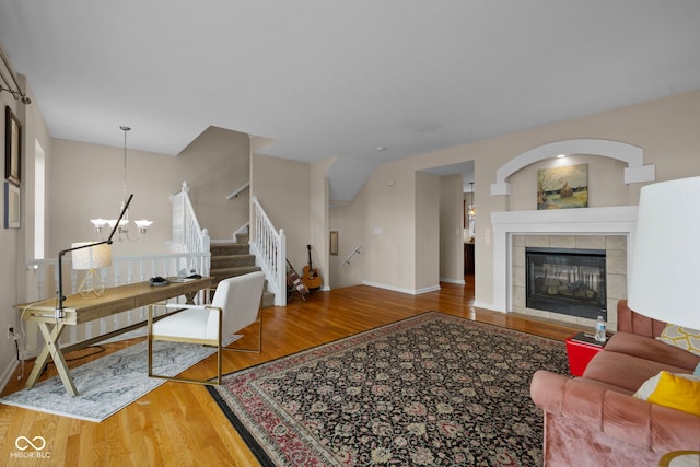 living room featuring hardwood / wood-style flooring, a fireplace, and an inviting chandelier