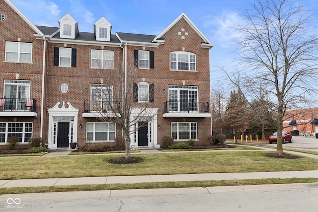 townhome / multi-family property featuring a front lawn