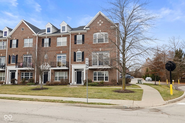 townhome / multi-family property featuring a front lawn