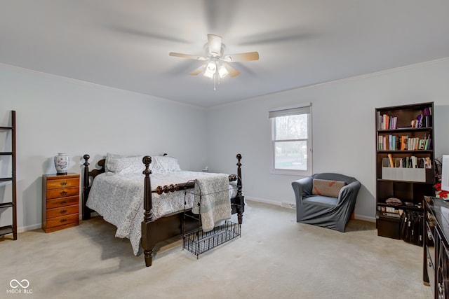 bedroom featuring ceiling fan, crown molding, and light colored carpet