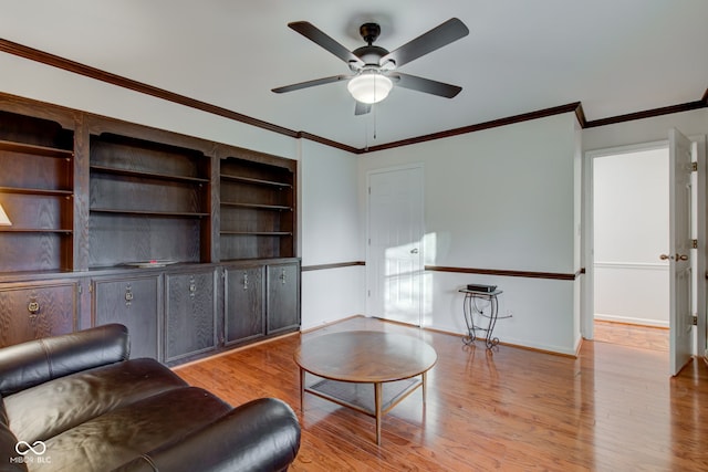 living room featuring light hardwood / wood-style floors, ceiling fan, and crown molding