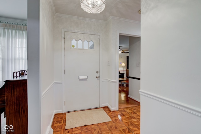 entrance foyer featuring ceiling fan, plenty of natural light, light parquet floors, and ornamental molding