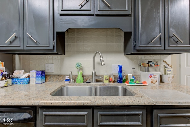 kitchen with sink, light stone countertops, and backsplash