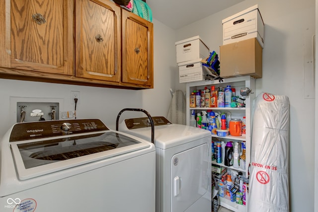 washroom featuring washing machine and clothes dryer and cabinets