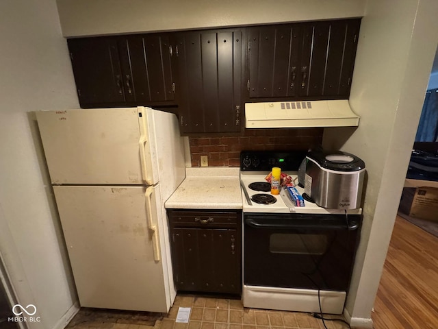 kitchen featuring white appliances, dark brown cabinetry, and exhaust hood