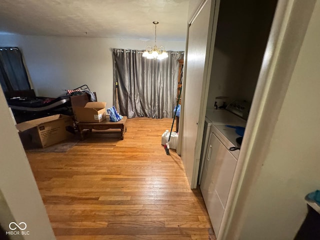 interior space with light wood-type flooring, separate washer and dryer, and a chandelier