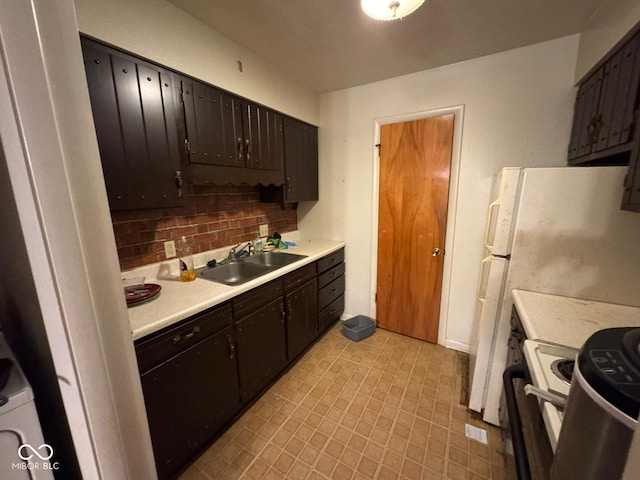 kitchen with tasteful backsplash, sink, range with electric stovetop, and white refrigerator