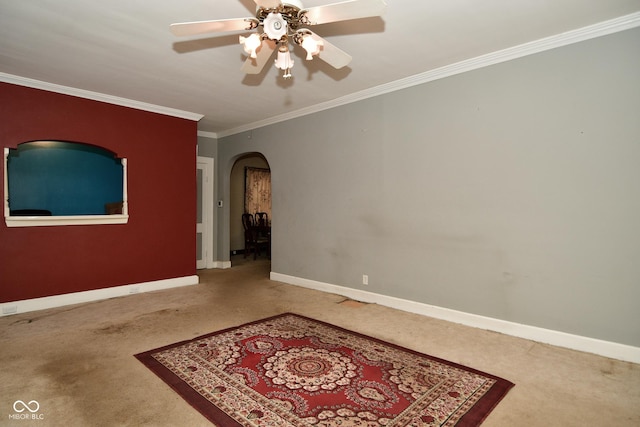 spare room featuring carpet, ceiling fan, and crown molding