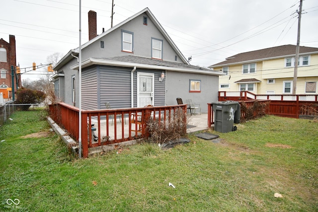 rear view of house with a deck and a yard