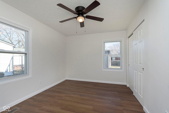 empty room featuring ceiling fan and dark wood-type flooring