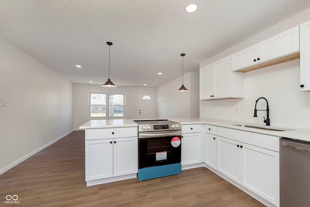 kitchen featuring kitchen peninsula, sink, hanging light fixtures, and appliances with stainless steel finishes