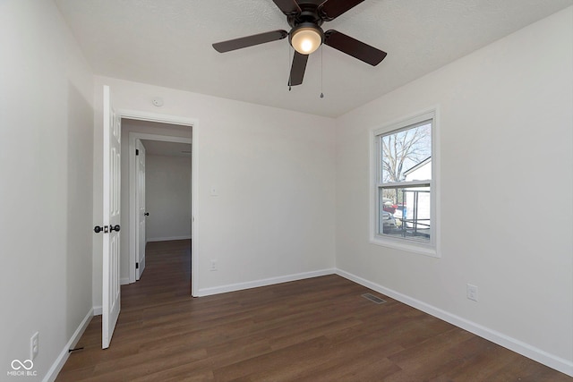 unfurnished room with ceiling fan and dark wood-type flooring