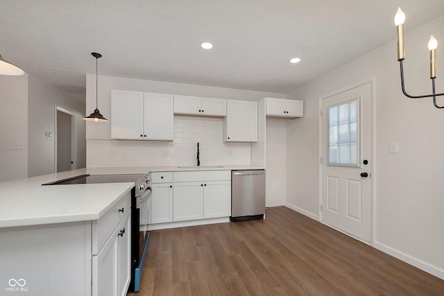 kitchen featuring appliances with stainless steel finishes, white cabinetry, hanging light fixtures, and sink