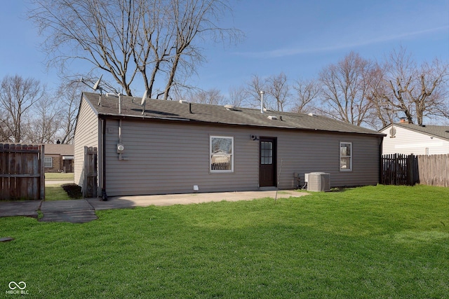 rear view of house featuring a lawn, central air condition unit, and a patio area