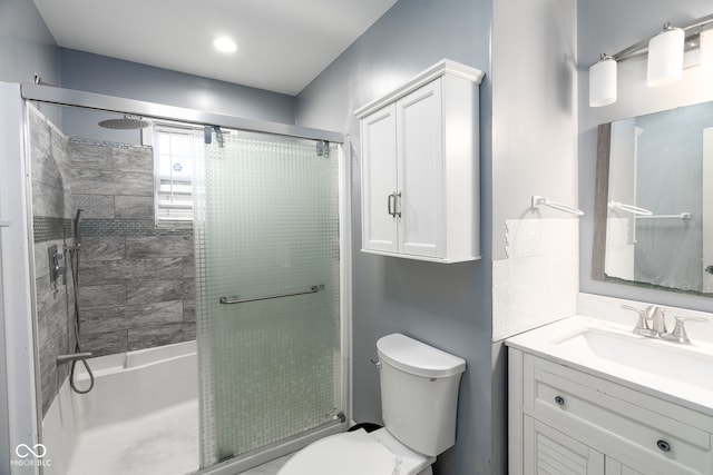 bathroom featuring vanity, toilet, and an enclosed shower