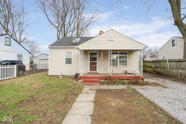 bungalow featuring covered porch and a front lawn