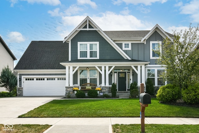 craftsman-style home featuring a garage, covered porch, and a front lawn