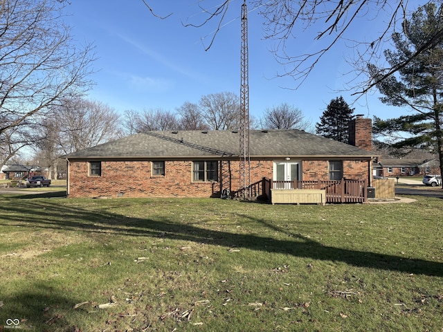 rear view of property featuring a yard and a wooden deck