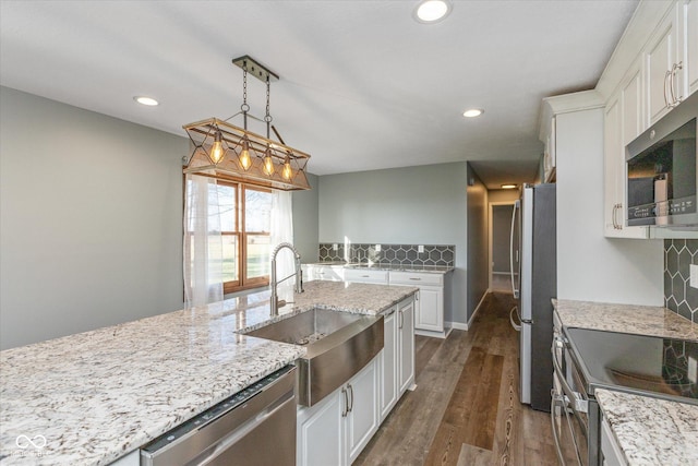 kitchen with sink, hanging light fixtures, dark hardwood / wood-style floors, white cabinetry, and stainless steel appliances