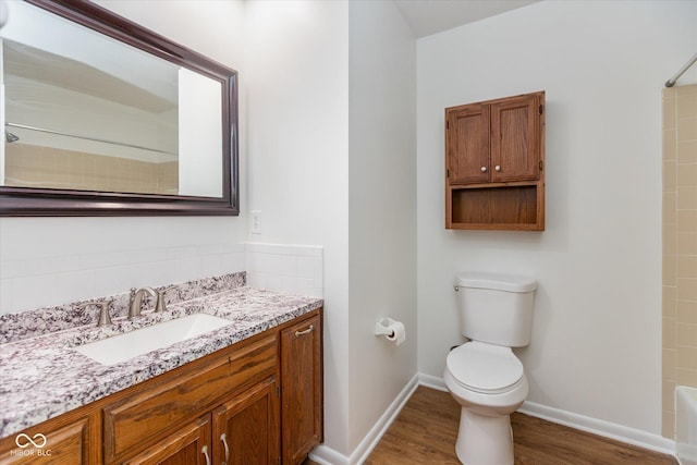 full bathroom with hardwood / wood-style floors, vanity, shower / bathtub combination, and toilet