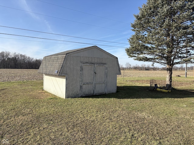 view of outdoor structure featuring a yard and a rural view