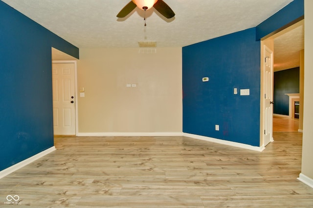 spare room with ceiling fan, light hardwood / wood-style flooring, and a textured ceiling