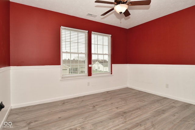 spare room featuring light hardwood / wood-style floors and ceiling fan