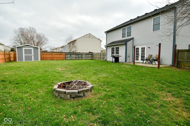 rear view of property featuring a fire pit, a patio area, and a lawn