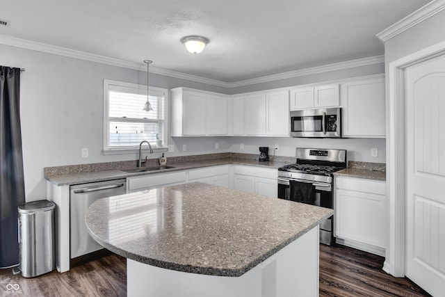 kitchen featuring white cabinets, hanging light fixtures, sink, appliances with stainless steel finishes, and a kitchen island